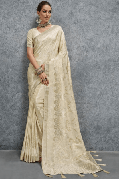 Elegant cream Banarasi silk saree with woven jacquard floral motifs and rich border, paired with matching blouse, perfect for wedding, festive and party wear.