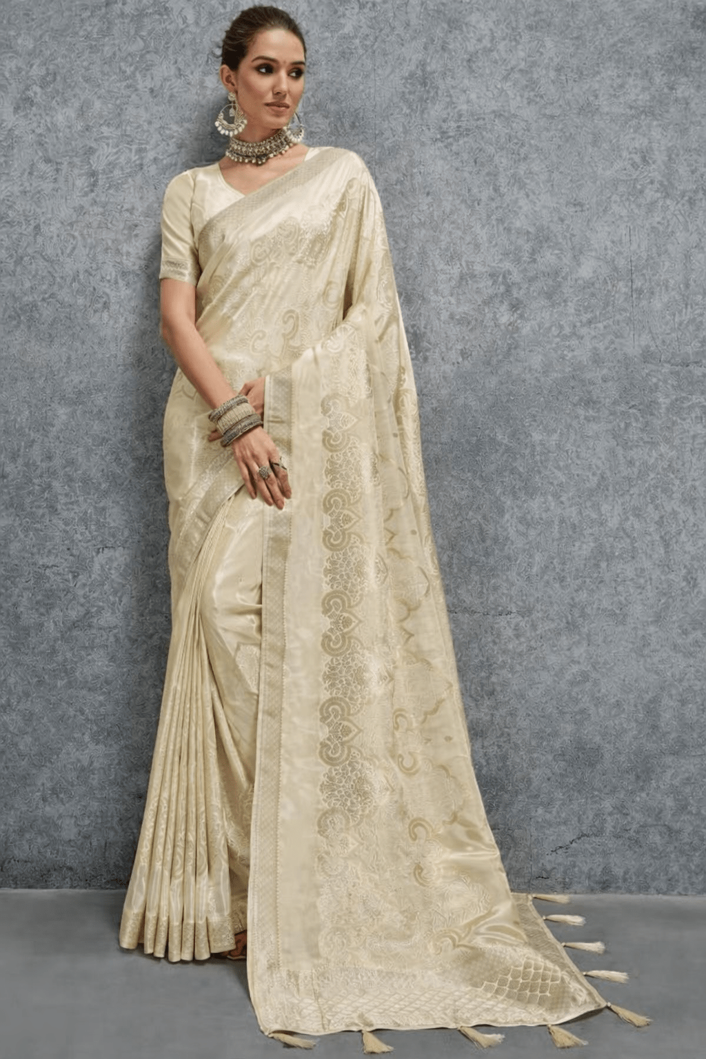 Elegant cream silk saree with woven jacquard floral motifs and rich border, paired with matching blouse, perfect for wedding, festive and party wear.