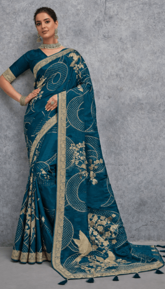 Teal blue Banarasi soft silk saree with gold zari woven floral and bird motifs, rich traditional border and designer pallu, perfect for wedding and festive wear.