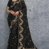 Black silk saree with intricate gold zari embroidery, featuring floral vine motifs and a richly woven traditional border, elegantly draped on a model against a grey textured background – perfect for wedding and festive wear.