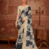 Model wearing an ivory silk saree with bold black floral prints and gold zari border.
