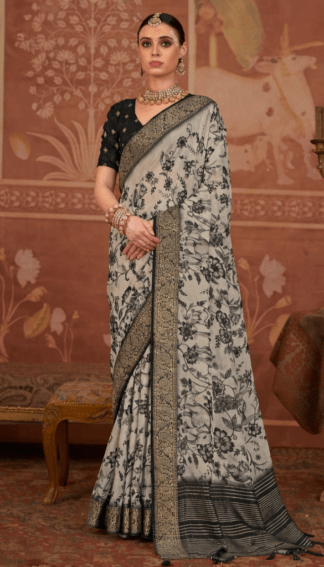 Model wearing a black and grey floral printed silk saree with intricate zari border, paired with a black blouse