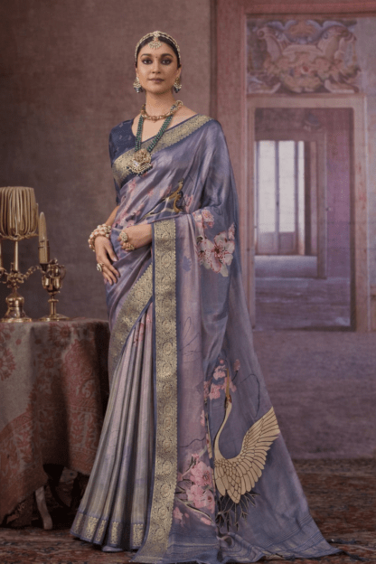 Steel grey silk saree with gold zari border, floral prints, and crane motif on the pallu.