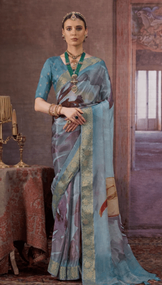 Sky blue silk saree with gold zari woven border and artistic abstract prints on the drape and pallu.