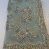 organza saree with gold zari and sequin floral embroidery and scalloped border, laid flat
