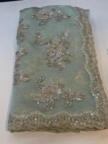 organza saree with gold zari and sequin floral embroidery and scalloped border, laid flat