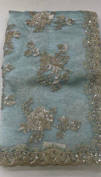 organza saree with gold zari and sequin floral embroidery and scalloped border, laid flat