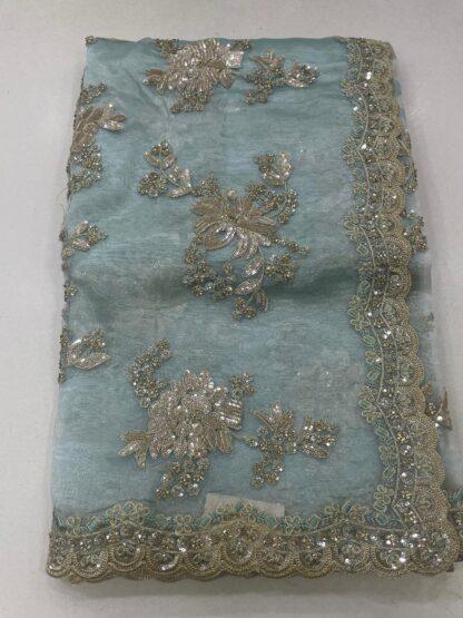 organza saree with gold zari and sequin floral embroidery and scalloped border, laid flat