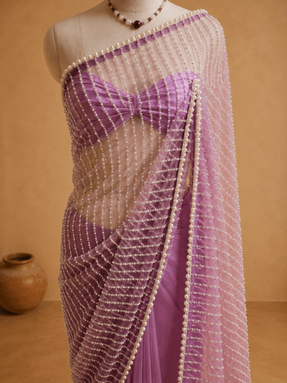 Full-length lavender pearl-embellished net saree draped on mannequin against a beige backdrop