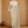 Ivory net saree with sequin floral vine embroidery and matching full-sleeve blouse, styled on mannequin