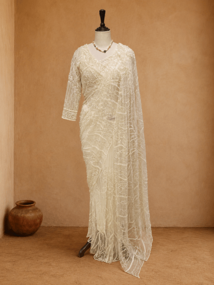 Ivory net saree with sequin floral vine embroidery and matching full-sleeve blouse, styled on mannequin