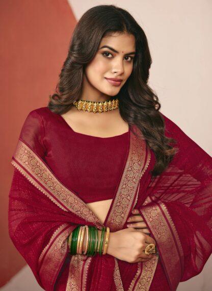 Woman wearing maroon chiffon saree with golden zari border and matching blouse