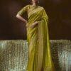 Woman wearing olive green zari woven silk saree with meenakari border and embroidered blouse