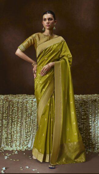 Woman wearing olive green zari woven silk saree with meenakari border and embroidered blouse