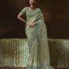 Woman wearing pistachio green organza saree with zari embroidery and scalloped border