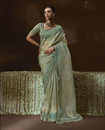 Woman wearing pistachio green organza saree with zari embroidery and scalloped border