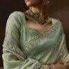 Woman wearing pistachio green organza saree with zari embroidery and scalloped border