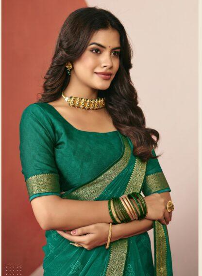 Woman wearing emerald green chiffon saree with golden zari border and matching blouse