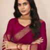 Woman wearing rani pink chiffon saree with golden zari border and matching blouse