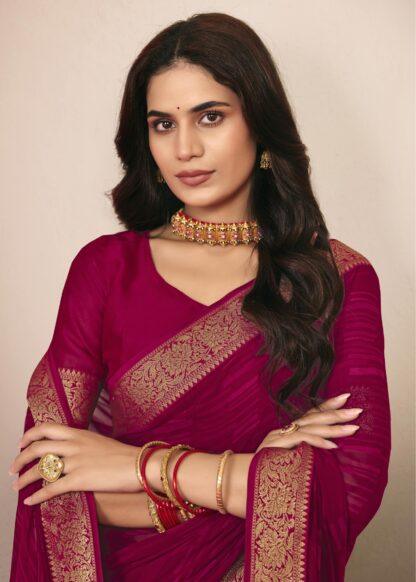 Woman wearing rani pink chiffon saree with golden zari border and matching blouse