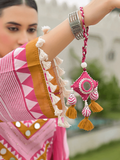 Woman wearing rani pink polka dot print cotton kurti palazzo set with mirror work neckline