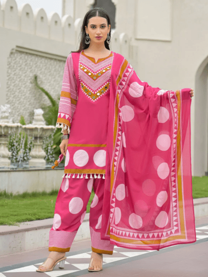 Woman wearing rani pink polka dot print cotton kurti palazzo set with mirror work neckline