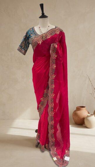Rani pink saree with scalloped embroidered border and teal blue blouse displayed on a mannequin at Sagar Sarees