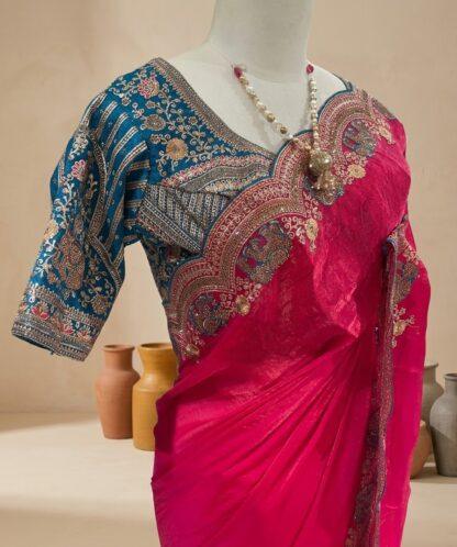 Rani pink saree with scalloped embroidered border and teal blue blouse displayed on a mannequin at Sagar Sarees