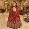 Red bridal lehenga with heavy zari and mirror embroidery and net dupatta on a mannequin at Sagar Sarees