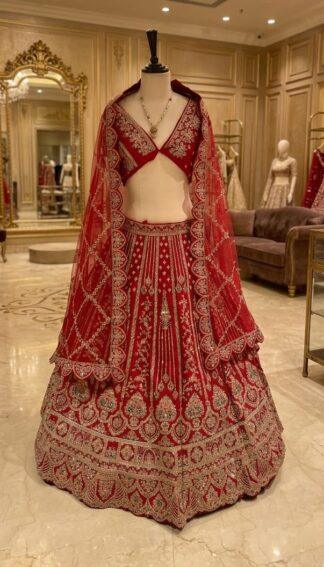 Red bridal lehenga with heavy zari and mirror embroidery and net dupatta on a mannequin at Sagar Sarees