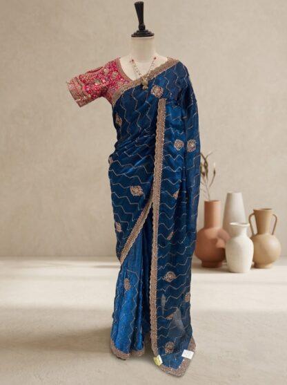 blue saree with zigzag sequin work, embroidered border and contrast pink blouse displayed on a mannequin at Sagar Sarees